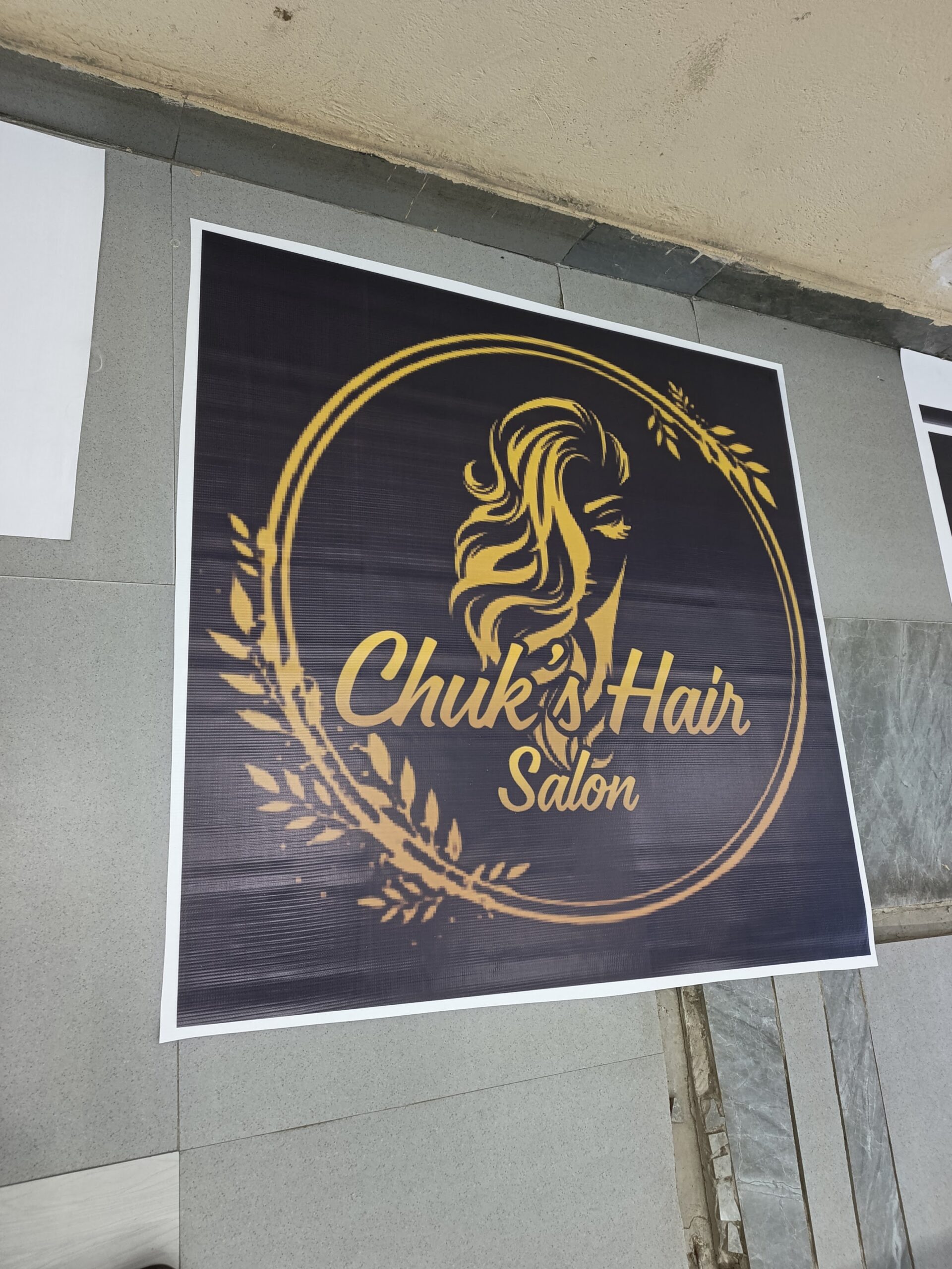 Gold-on-black signage panel produced for Chuk's Hair Salon