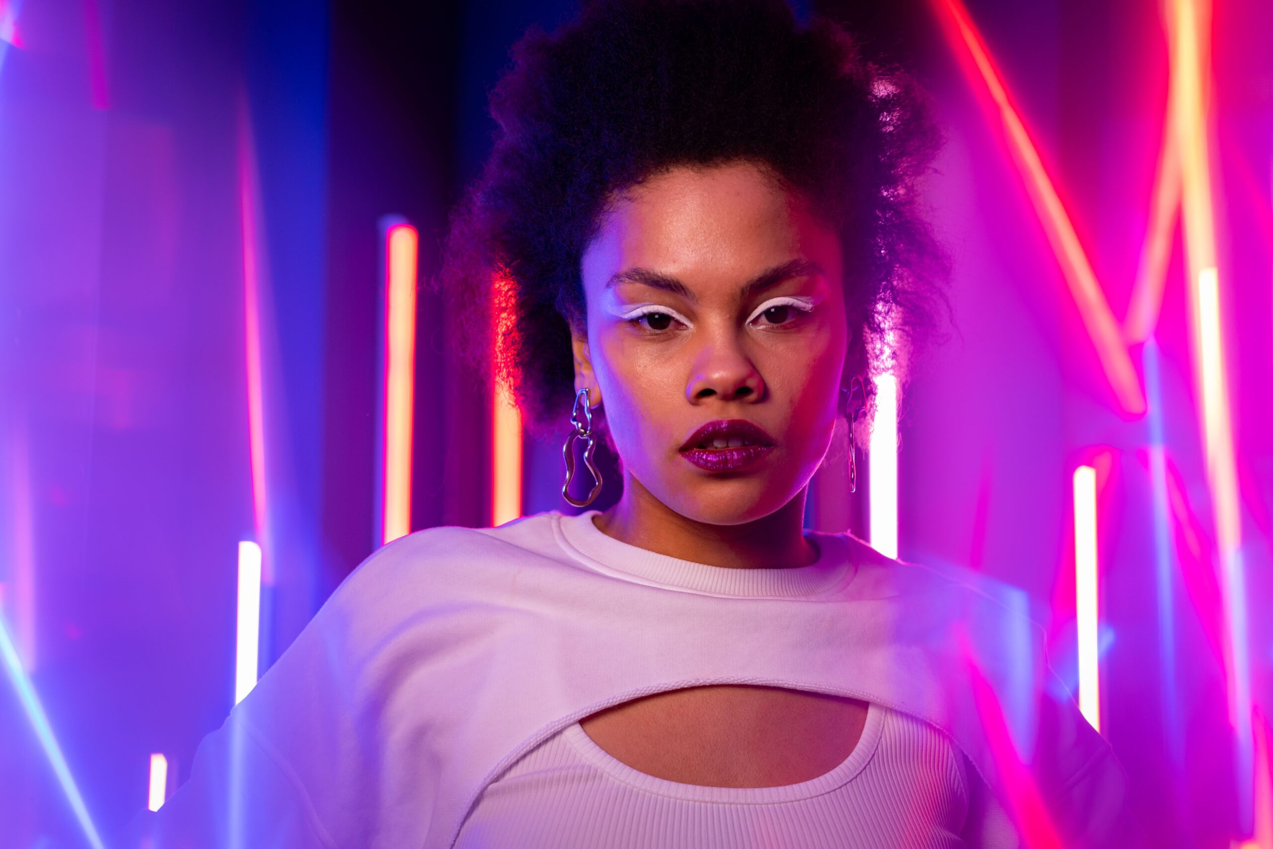 Portrait with afro hairstyle lit by vivid neon colour