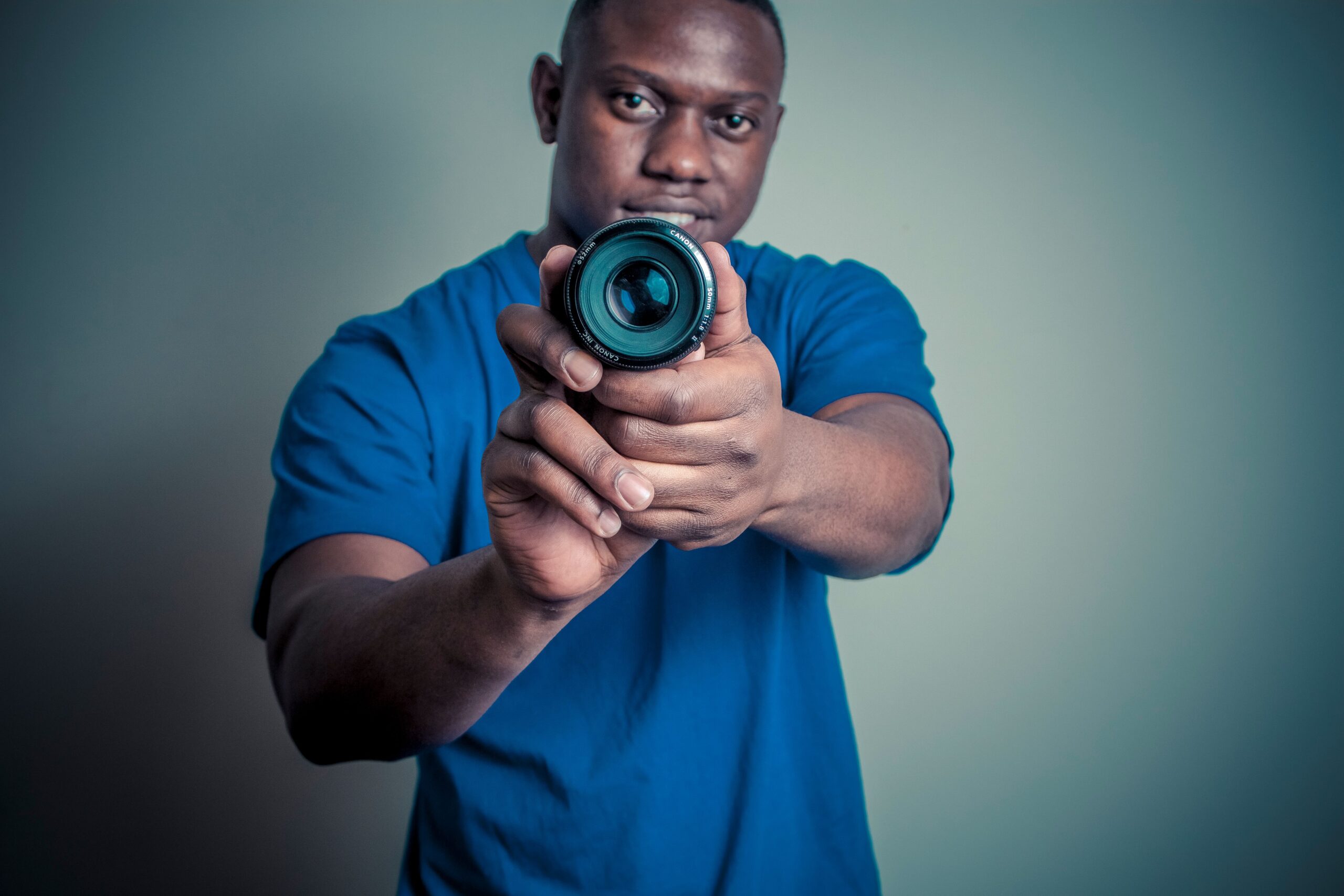Photographer holding a camera lens toward the viewer